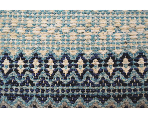 Detaliu al unui covor țesut cu model geometric