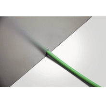 Furtun verde de irigare din plastic pe un fundal deschis