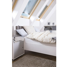 Dormitor luminos cu ferestre de mansardă, pat, noptieră și covor