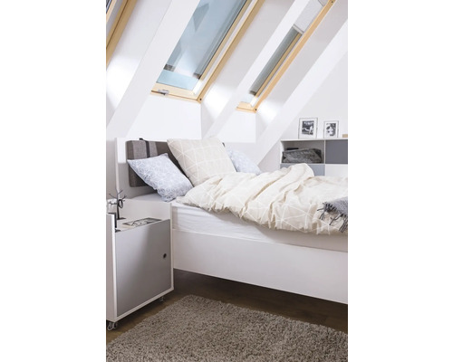 Dormitor luminos cu ferestre de mansardă, pat, noptieră și covor