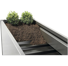 Jardinieră înaltă umplută cu plante și pământ