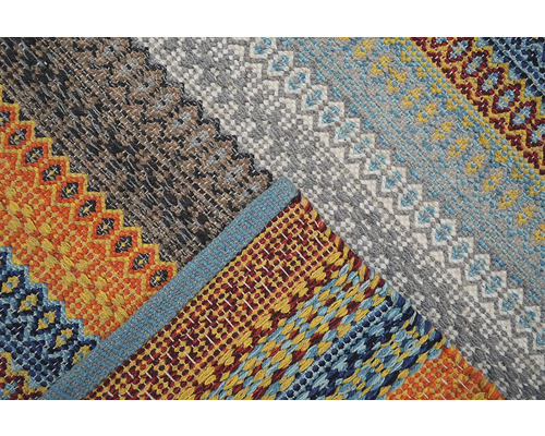 Prim-plan cu un covor cu model în dungi și modele geometrice.