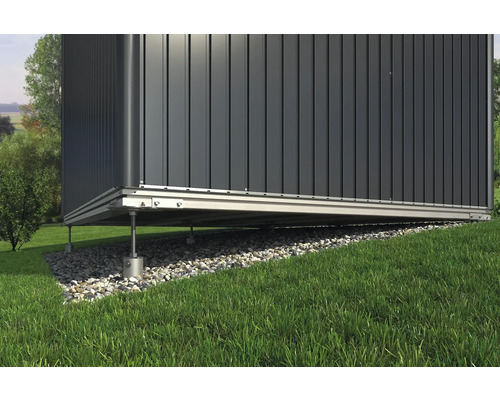 Vedere detaliată a unei căsuțe de grădină cu fundație pe o pantă de gazon.