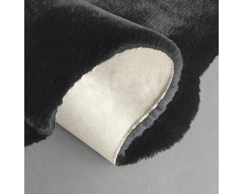 Covor negru cu colțul întors pentru a arăta partea din spate