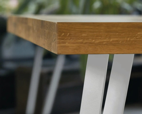 Vizualizare detaliată a unui blat de masă din lemn cu picioare metalice