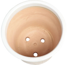 Vedere interioară a unui ghiveci de flori din teracotă cu găuri de drenaj