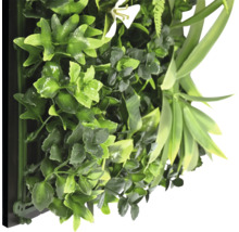 Perete artificial de plante cu diverse frunze verzi și o floare albă