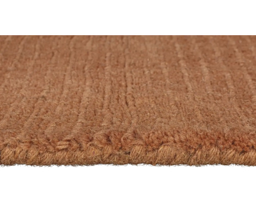 Prim-plan cu un covor maro cu structură buclată.