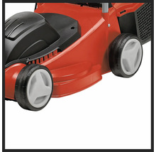 Prim-plan cu o mașină de tuns iarba roșie, cu elemente negre și albe.