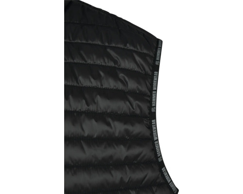 Detaliu al unei veste de lucru matlasate negre cu logo-ul Hammer Workwear.