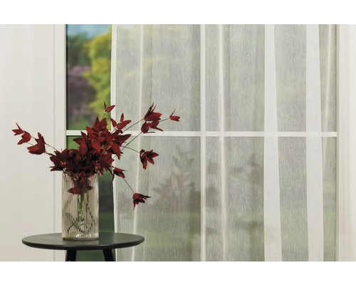 Scenă cu o perdea transparentă în fața unei ferestre și o vază cu flori pe o masă