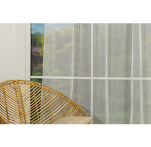 Scenă cu o perdea transparentă în fața unei ferestre și un scaun din ratan