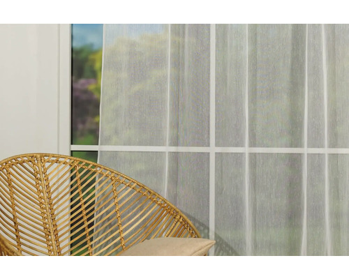 Scenă cu o perdea transparentă în fața unei ferestre și un scaun din ratan