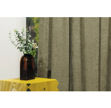 Șaluri decorative din material textil lângă o vază cu plante pe o masă.