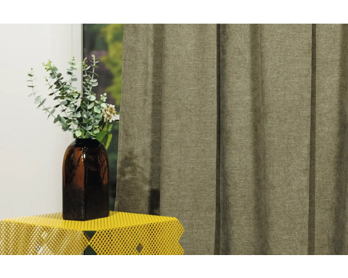 Șaluri decorative din material textil lângă o vază cu plante pe o masă.