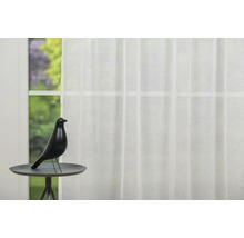 Fereastră decorativă cu perdea și pasăre pe o măsuță laterală