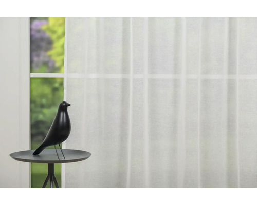 Fereastră decorativă cu perdea și pasăre pe o măsuță laterală