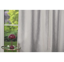 Șaluri decorative în fața unei ferestre cu lampă de masă.