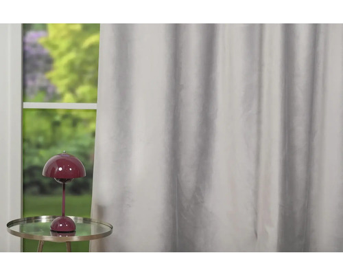 Șaluri decorative în fața unei ferestre cu lampă de masă.