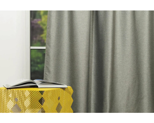 Cortină gri lângă o fereastră cu o carte pe o masă