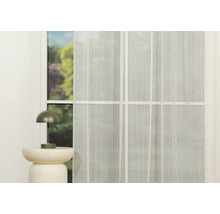 Fereastră cu perdea transparentă și lampă de masă