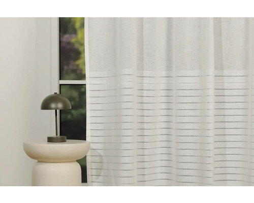 Fereastră decorativă cu perdea și lampă pe o măsuță laterală