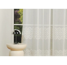 Șaluri decorative din voal cu model floral în fața unei ferestre.