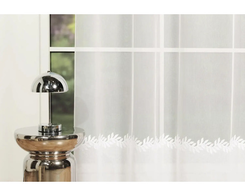 Șaluri decorative în fața ferestrei cu model de frunze și lampă pe măsuța laterală