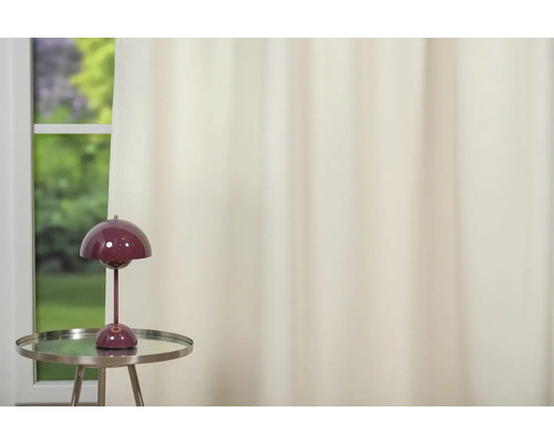 Cameră decorativă cu lampă de masă pe o măsuță laterală și perdea în fața ferestrei