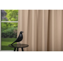 Statuie decorativă de pasăre pe o măsuță în fața unei ferestre cu perdea