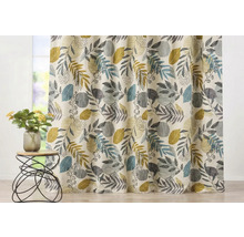 Cortină cu model de frunze în fața unei ferestre și o măsuță cu o vază cu flori.