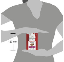 Pachet de hrană pentru pisici Purina Gourmet Mon Petit Intense între două mâini, cu indicarea dimensiunii de 127 mm.