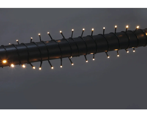 Ghirlandă luminoasă cu LED-uri alb cald, înfășurată în jurul unei țevi închise la culoare.