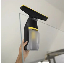 Aspirator de geamuri utilizat pentru curățarea unei suprafețe din sticlă.