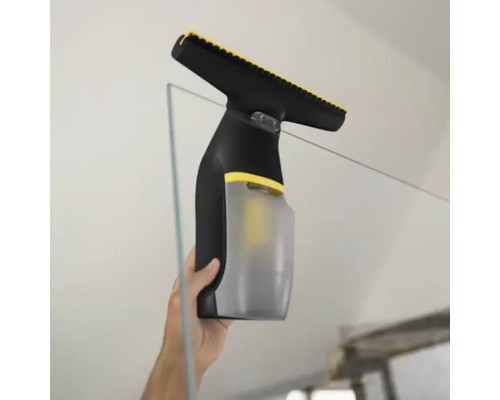 Aspirator de geamuri utilizat pentru curățarea unei suprafețe din sticlă.