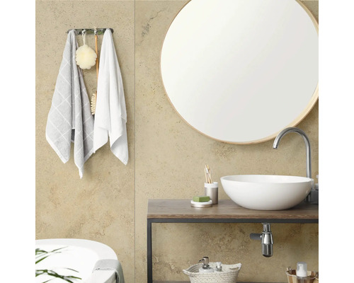 Baie modernă cu oglindă rotundă, lavoar pe blat pe un corp de mobilier din lemn și cârlige pentru prosoape cu accesorii.