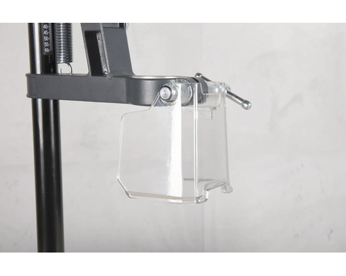 Protecție transparentă împotriva așchiilor la un suport de găurit din metal.