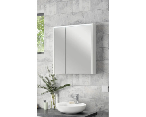 Dulap cu oglindă cu două uși și iluminare LED deasupra unui lavoar pe blat într-o baie modernă, luminoasă, cu faianță cu aspect de piatră.