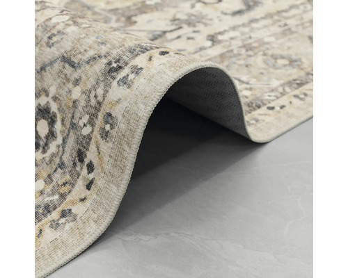 Covor cu model oriental vintage, prim-plan cu marginea surfilată și spatele.