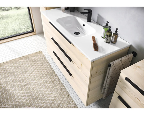 Mască pentru chiuvetă modernă din lemn deschis cu trei sertare, mânere negre, lavoar din ceramică albă și baterie neagră în baie.