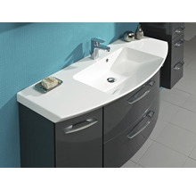 Mobilier de baie cu lavoar alb, baterie cromată și dulap gri închis lucios cu front curbat și mânere metalice.