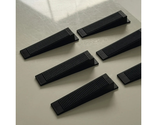 Şase pene din plastic negru cu suprafaţă striată pentru nivelarea denivelărilor.