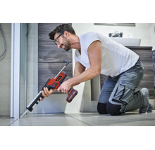 Un meșter folosește un pistol de silicon Einhell cu acumulator pentru a etanșa profesional îmbinarea unei cabine de duș în baie.