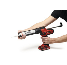 Pistol pentru cartușe cu acumulator Einhell cu un tub de acril introdus, ținut în mâna unui utilizator.