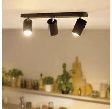 Plafonieră modernă cu trei spoturi cilindrice montate pe o șină dreptunghiulară într-un spațiu de locuit