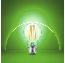 Bec cu filament LED Philips cu dulie E27 și formă transparentă din sticlă.