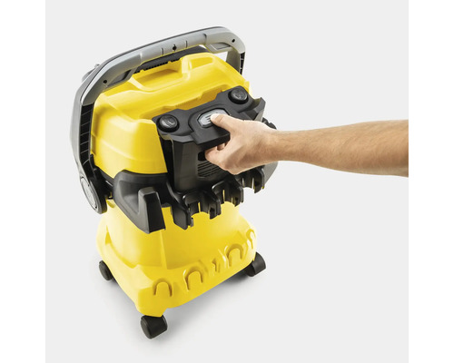 Mână acționând mecanismul de blocare al aspiratorului multifuncțional Kärcher cu suport pentru accesorii.