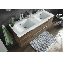 Lavoar dublu cu blat ceramic alb și mască de mobilier cu aspect de lemn cu două sertare într-o baie amenajată modern.