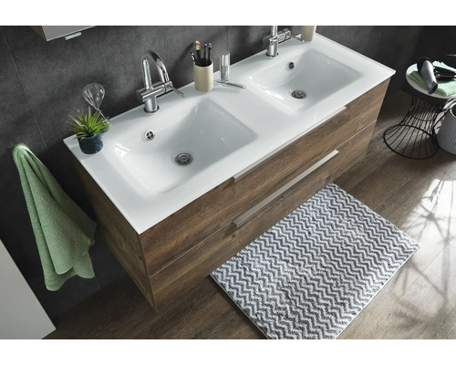 Lavoar dublu cu blat ceramic alb și mască de mobilier cu aspect de lemn cu două sertare într-o baie amenajată modern.