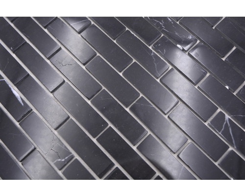 Plăci de mozaic dreptunghiulare din piatră naturală, așezate în model herringbone.